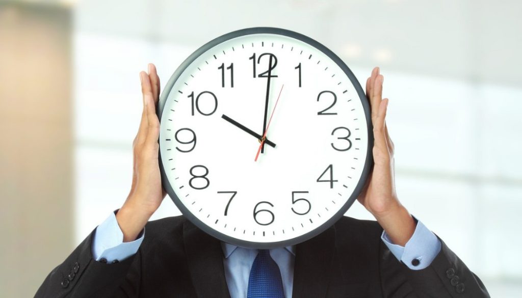 Homme en costume seul, horloge à la main, journée de travail