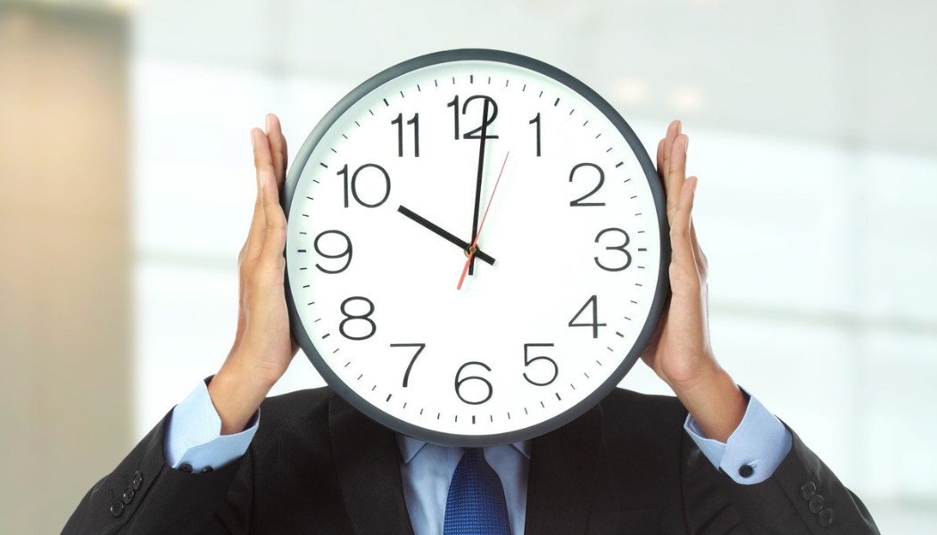Homme en costume seul, horloge à la main, journée de travail